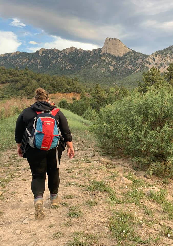 Flora hiking to Lover's Leap at sunrise · Philmont · Tooth of Time in the distance