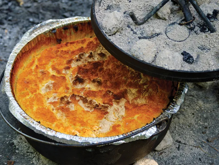Philmont Ranger peach cobbler in a Dutch oven over coals