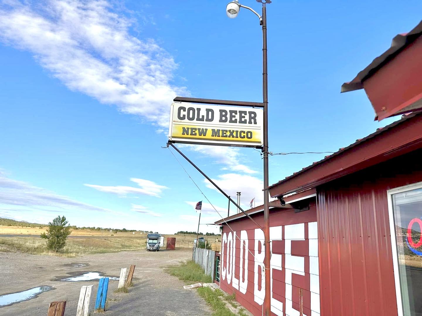 Cold Beer NM · sign and sky · red roof · American flag