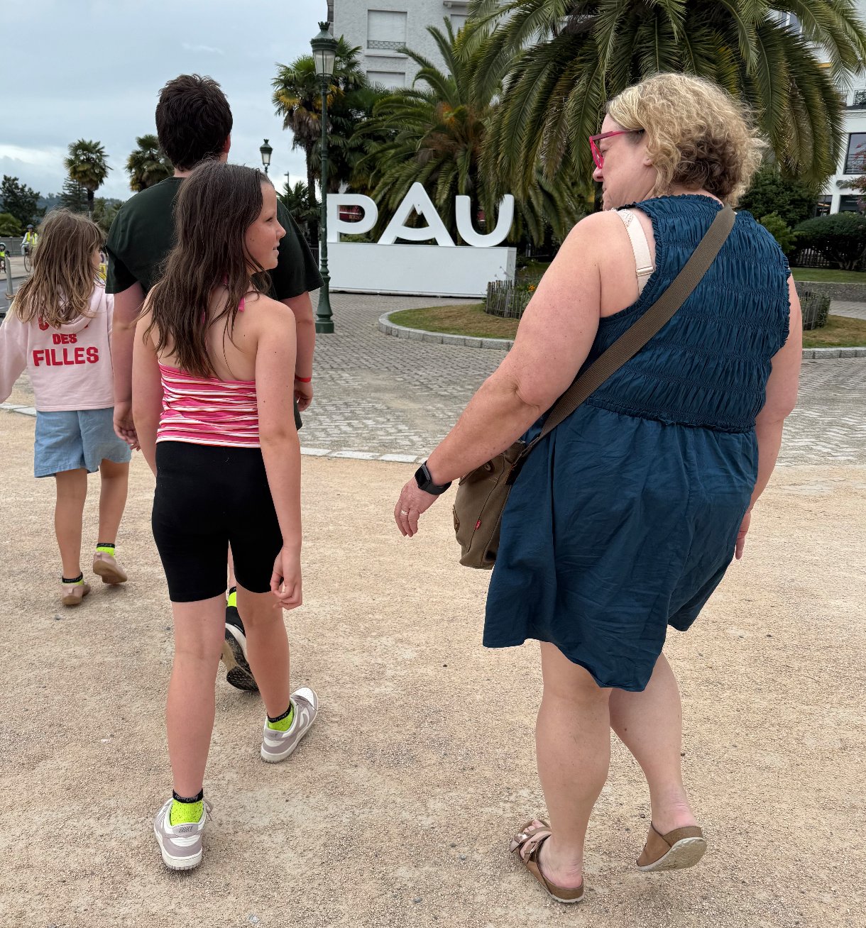 Flora and the kids walking toward the PAU sign · Pau, France